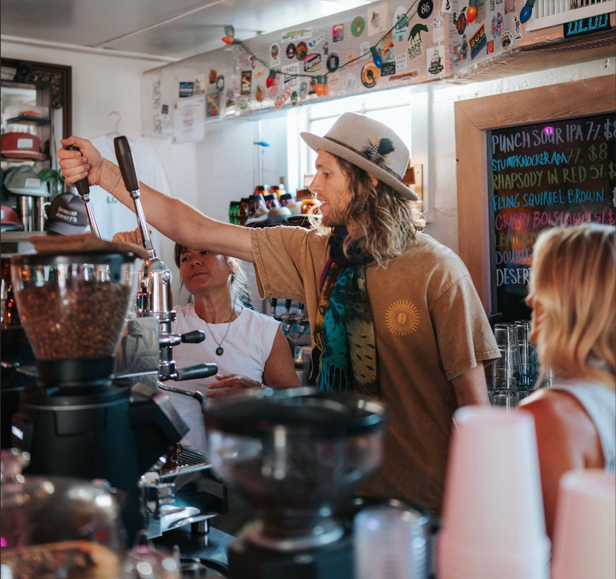 3rd Wave Coffee head Roaster in a coffee shop preparing a latte with a wholesale client at Spinster Abbotts for training.