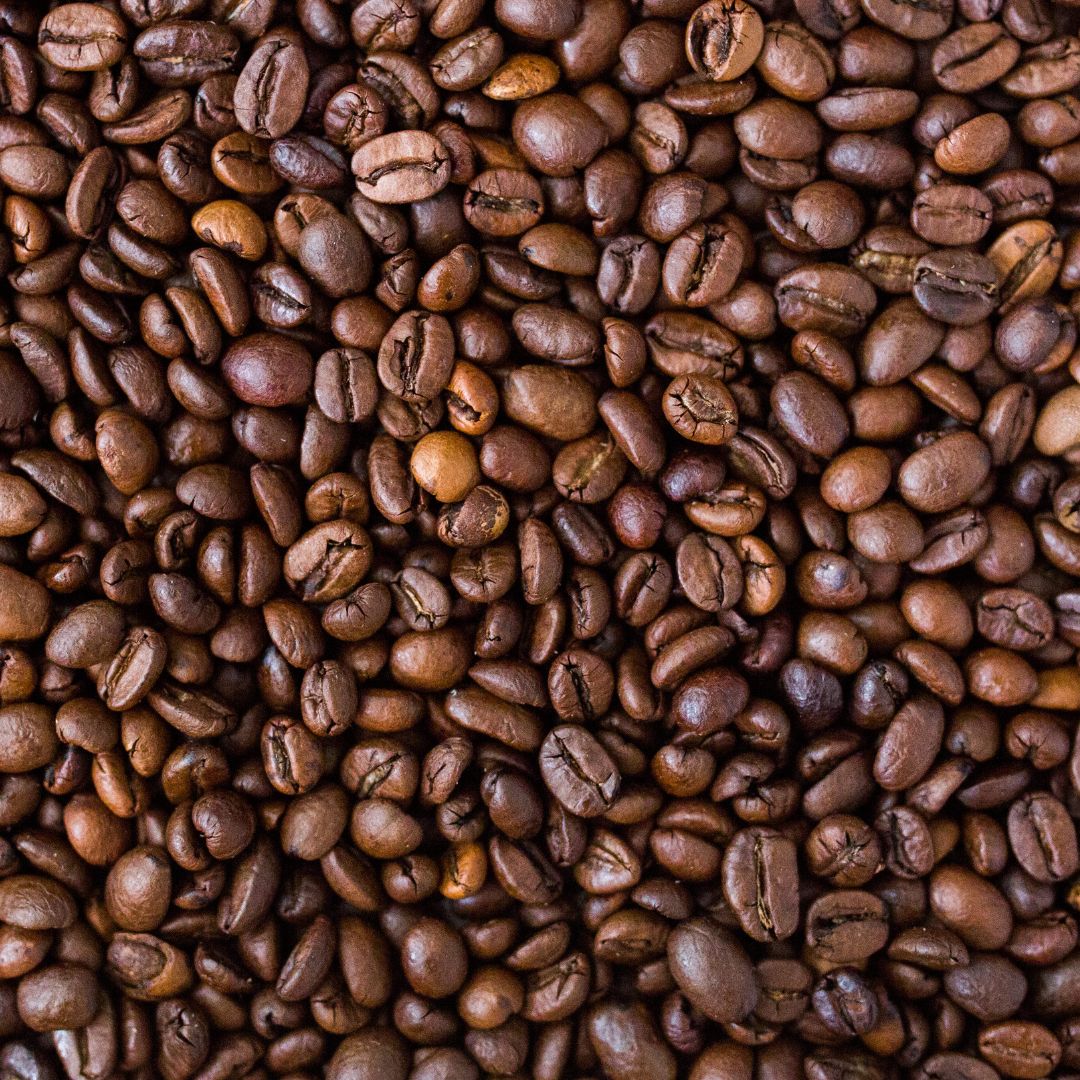 A close-up image of roasted coffee beans filling the entire frame for Organic Honduras COMSA Marcala Coffee Beans.