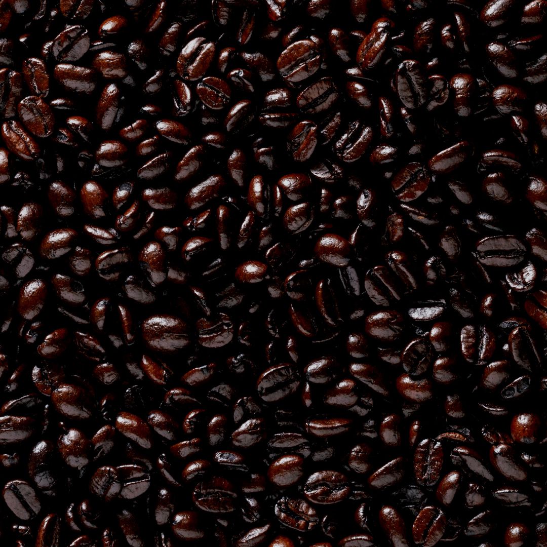 A close-up image of roasted coffee beans showing a dark, oily texture indicative of a French roast level.